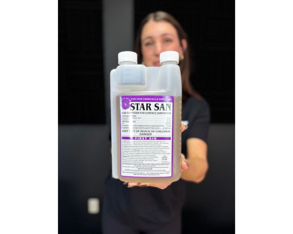 Person holding a bottle of Star San sanitizer with a blurred background